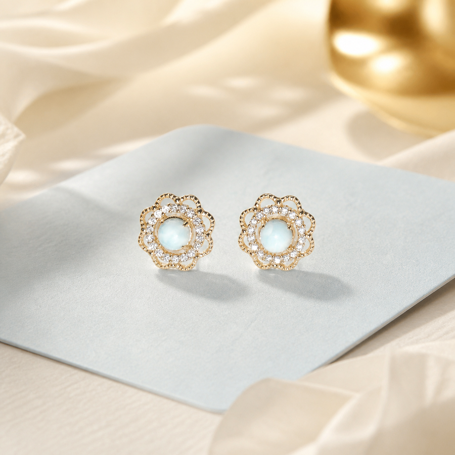 Blue bloom stud earrings on a softly warmed display background