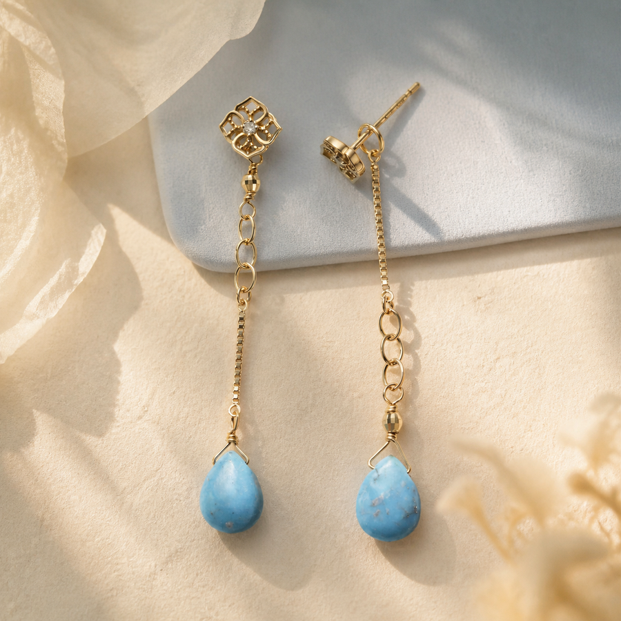 Long blue drop earrings with gold chain details