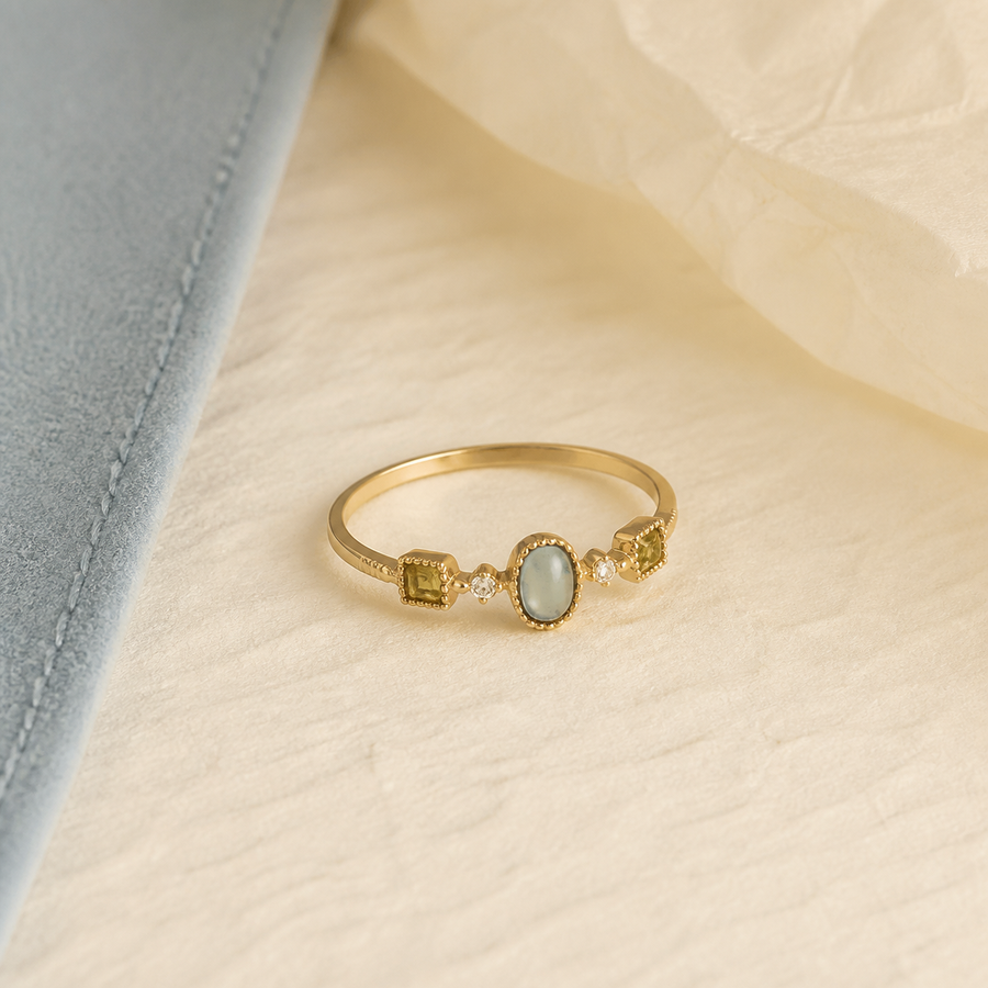 Soft opal ring with gold band and pale blue center stone