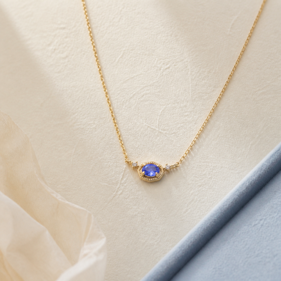 Blue petite necklace with gold chain on pale lace setting